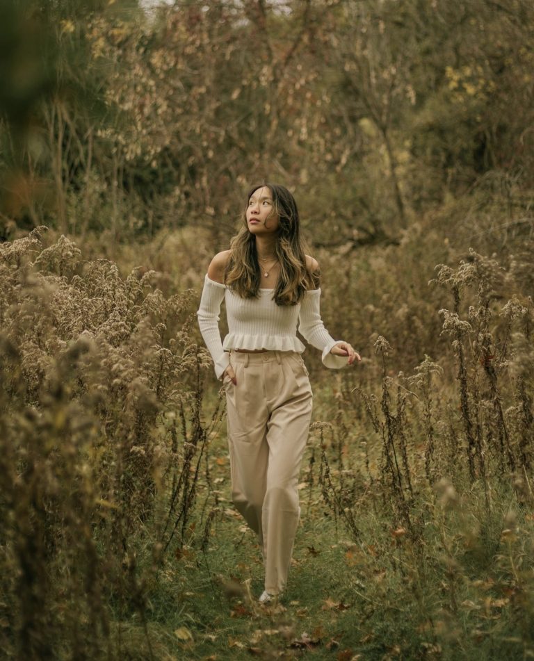 Mujer caminando sola por una pradera con expresión de descubrimiento, simbolizando cómo la ansiedad puede convertirse en aliada en el camino del crecimiento personal