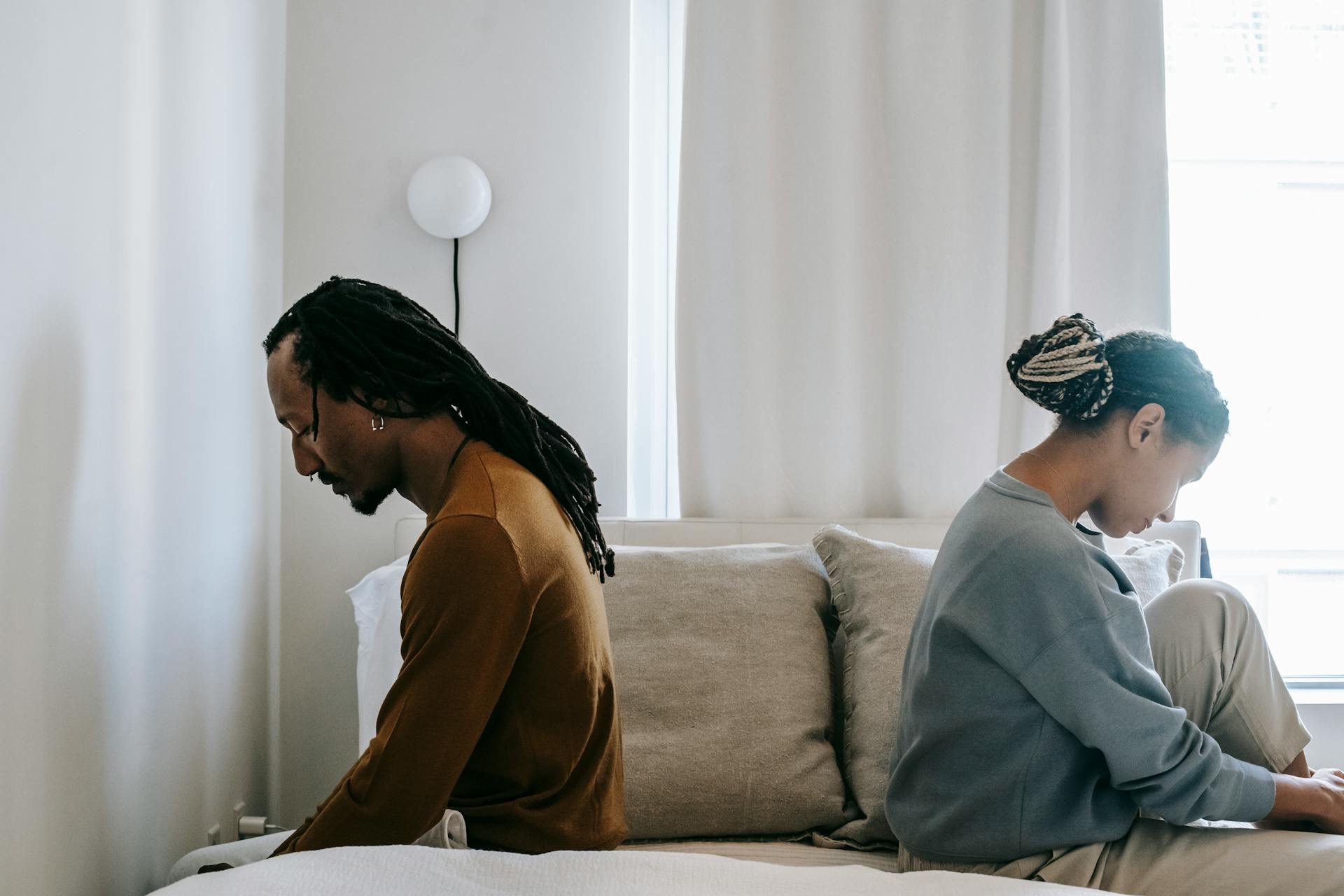 Pareja de espaldas después de una discusión, mostrando que las relaciones sanas también atraviesan conflictos.
