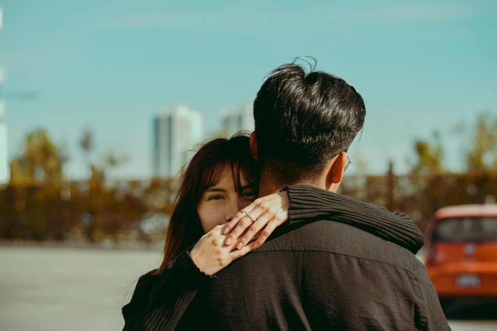 Mujer abrazando a su pareja con expresión de duda y miedo, reflejando el dilema entre salvar la relación o priorizar su propio bienestar emocional.
