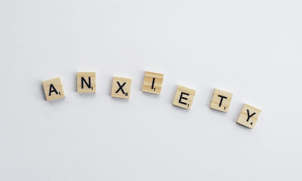 La palabra ansiedad formada con fichas de scrabble que representa el reto de comprender y transformar las emociones para iniciar un proceso de sanación