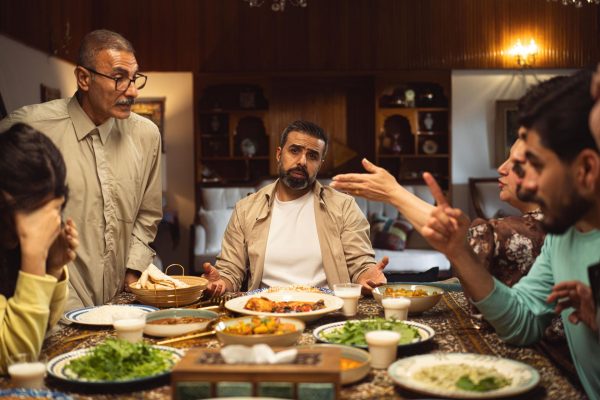 Familia discutiendo en la mesa durante una comida, representando patrones de relación aprendidos en la infancia y conflictos familiares que influyen en las relaciones adultas.